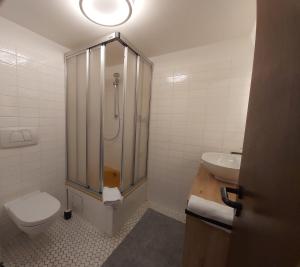 uma casa de banho com um chuveiro, um WC e um lavatório. em Förde Koje em Westerholz