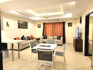 uma sala de estar com um sofá, uma mesa e cadeiras em Bright & Beautiful 1 Bed Apt In Bahria Town em Rawalpindi