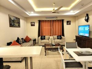 a living room with a couch and a tv at Bright & Beautiful 1 Bed Apt In Bahria Town in Rawalpindi