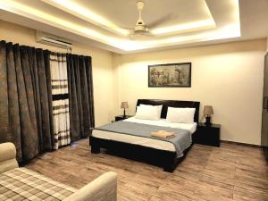ein Schlafzimmer mit einem Bett und einem Sofa darin in der Unterkunft Bright & Beautiful 1 Bed Apt In Bahria Town in Rawalpindi