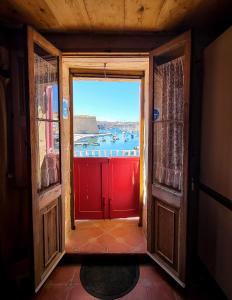 an open door to a room with a view of a harbor at 1500 Little Pink House in Kalkara Creek in Kalkara