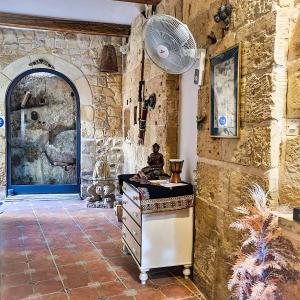 a kitchen with a stone wall and a fan at 1500 Little Pink House in Kalkara Creek in Kalkara