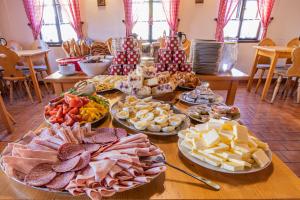 a table filled with different types of cheese and meats at Penzion Sněžná Volary in Volary