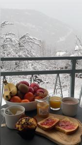 a table with a bowl of fruit and a plate of bread at Bel appartement 8 personnes à Saint Chaffrey in Saint-Chaffrey