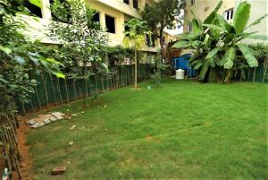 新德里的住宿－Hotel Arch International，一个带栅栏和绿草的院子