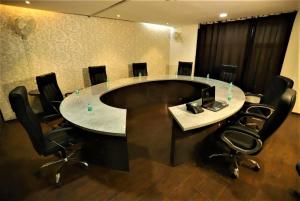 新德里的住宿－Hotel Arch International，一间会议室,配有圆桌和黑椅子
