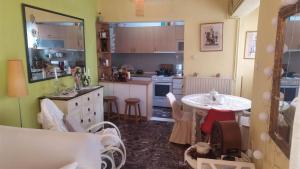 a kitchen with a table and a small table and chairs at Comfortable Central Appartment by a park in Larisa