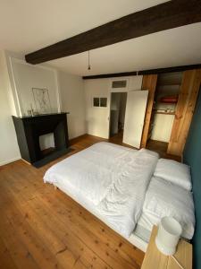 een slaapkamer met een groot wit bed en een open haard bij Atypique maison rénovée 3 grandes chambres - idéal famille et travailleurs in Saint-Omer