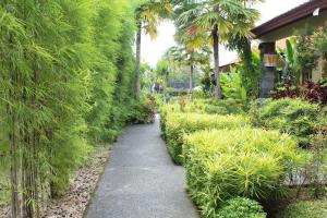 einen Pfad in einem Garten mit Bäumen und Pflanzen in der Unterkunft Darra Ria Villa Ubud in Ubud