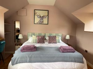 a bedroom with a large bed with purple pillows at The Hayloft, Exmoor in Withypool