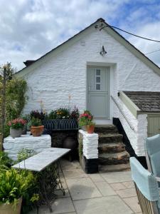 a white building with stairs and a door at The Hayloft, Exmoor in Withypool