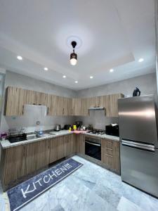 La cuisine est équipée d'armoires en bois et d'un réfrigérateur en acier inoxydable. dans l'établissement Antonios luxury apartments, à Fès