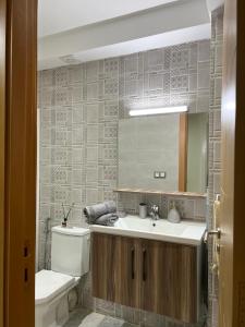 a bathroom with a sink and a toilet and a mirror at Antonios luxury apartments in Fez