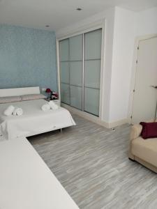 a hotel room with two beds and a couch at Villa 28 de julio Casa Rural con piscina en Granada in Granada +24 photos