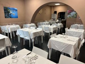 un comedor con mesas blancas y sillas blancas en B&B Dal Pres, en Bagnara Calabra