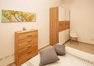 ein Schlafzimmer mit einer Kommode und einem Wandgemälde in der Unterkunft Amantea Apartment THE NEW in Amantea