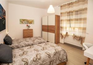 a bedroom with two beds and a dresser at Amantea Apartment THE NEW in Amantea