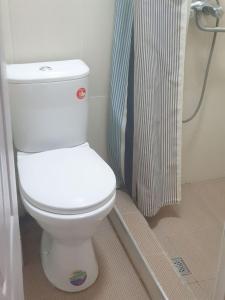 a bathroom with a white toilet and a shower at Квартира в центре города in Tashkent