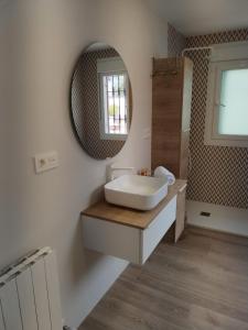 y baño con lavabo y espejo. en Villa 28 de julio Casa Rural con piscina en Granada en Granada
