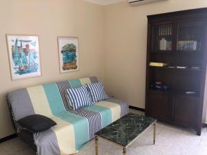a living room with a couch and a book shelf at Villa T5 avec jardin, 100m plage, clim, WiFi, pour 8-10 pers, Le Barcarès - FR-1-81-524 in Le Barcarès