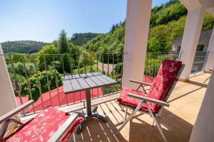een patio met 2 stoelen en een tafel op een balkon bij Kräuterhotel Villa Vontenie in Kordel
