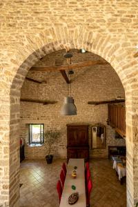 a room with a stone wall with a table and chairs at La Maison de Beaume in Créancey +15 photos