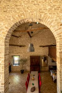 Cette chambre est dotée d'un mur en pierre avec une table et des chaises. dans l'établissement La Maison de Beaume, à Créancey