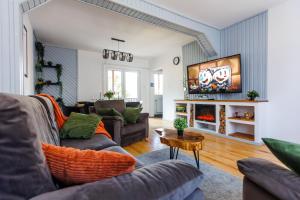 a living room with two couches and a flat screen tv at The Bear House 2 in Buşteni