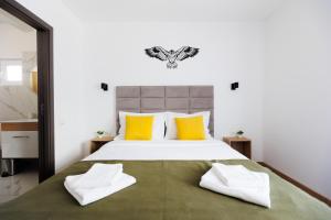 a bedroom with a large bed with yellow pillows at The Bear House 2 in Buşteni