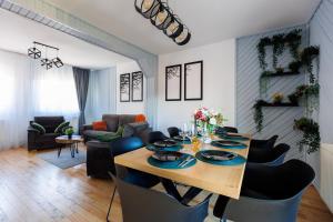 een eetkamer en een woonkamer met een tafel en stoelen bij The Bear House 2 in Buşteni