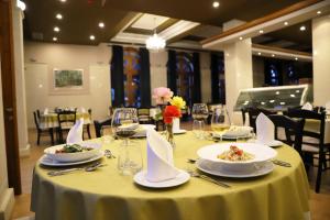 uma mesa com pratos de comida e copos de vinho em Hotel Colombo em Berati