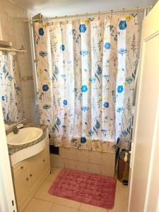 a bathroom with a sink and a shower curtain at Superbe appartement près du métro 4 proche Paris in Bagneux