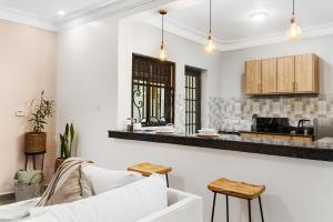 a living room with a white couch and a kitchen at Polo Apartments in Kampala