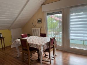 a dining room with a table and chairs and a window at FeWo Alkapa in Hilzingen