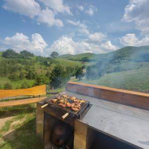 a grill with food cooking on it in a field at Zlatibor Wild nest Rabbit in Zlatibor