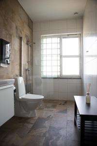 ein Bad mit einem WC, einem Waschbecken und einem Fenster in der Unterkunft Eksjö Longstay in Eksjö