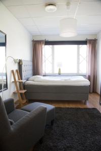 エークシェーにあるEksjö Longstayのベッドルーム1室(ベッド1台、椅子、ソファ付)