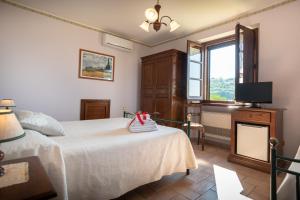 um quarto com uma cama, uma televisão e uma janela em Agriturismo La Rocca Assisi em Petrignano