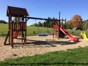 a playground with two swings and a slide at APARTMÁNY MAXOV in Lučany nad Nisou