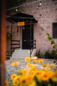 ein Schild vor einer Tür mit gelben Blumen in der Unterkunft Village Jazz in Chimankend