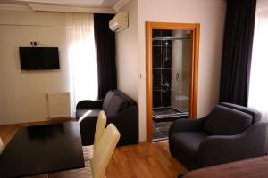伊斯坦堡的住宿－警長公寓酒店，客厅配有两把椅子、一张沙发和淋浴