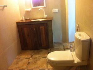 ein Bad mit einem WC und einem Waschbecken in der Unterkunft Fishermens Lodge & Restaurant in Ranna
