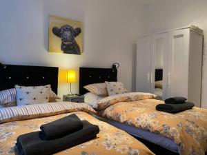 een slaapkamer met 2 bedden en zwarte handdoeken bij Courtyard Cottage in Lockerbie
