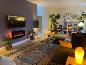 a living room with a couch and a fireplace at Courtyard Cottage in Lockerbie