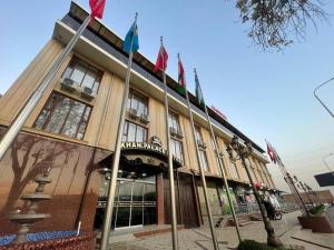 un edificio con banderas delante en Khan Palace Hotel, en Yakkasaray