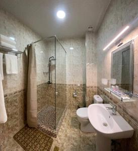 y baño con ducha, aseo y lavamanos. en Khan Palace Hotel, en Yakkasaray