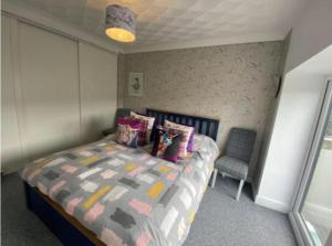 a small bedroom with a bed and a chair at Valley Views in Llwyn-y-pia