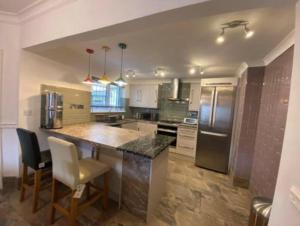 a large kitchen with a counter and a refrigerator at Valley Views in Llwyn-y-pia