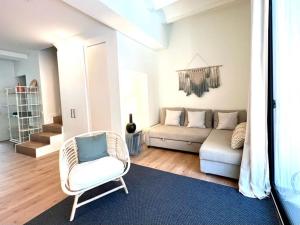 a living room with a couch and a chair at Hauzify I Apartaments Sant Pau in San Pol de Mar