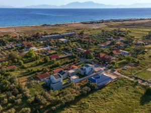 una vista aerea di un villaggio vicino all'oceano di TheaSea Luxury Suites - Kallikrateia Halkidiki a Nea Kalikratia